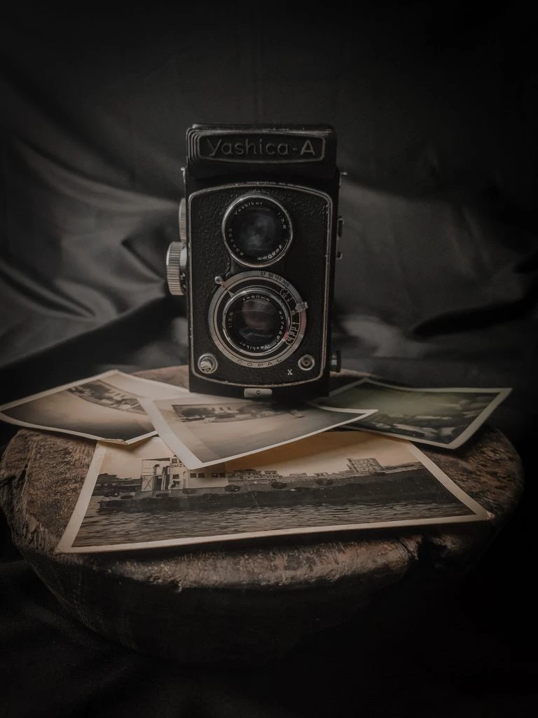 A dark glass beard oil bottle beside a wooden beard brush on a linen cloth, photographed in warm window light.